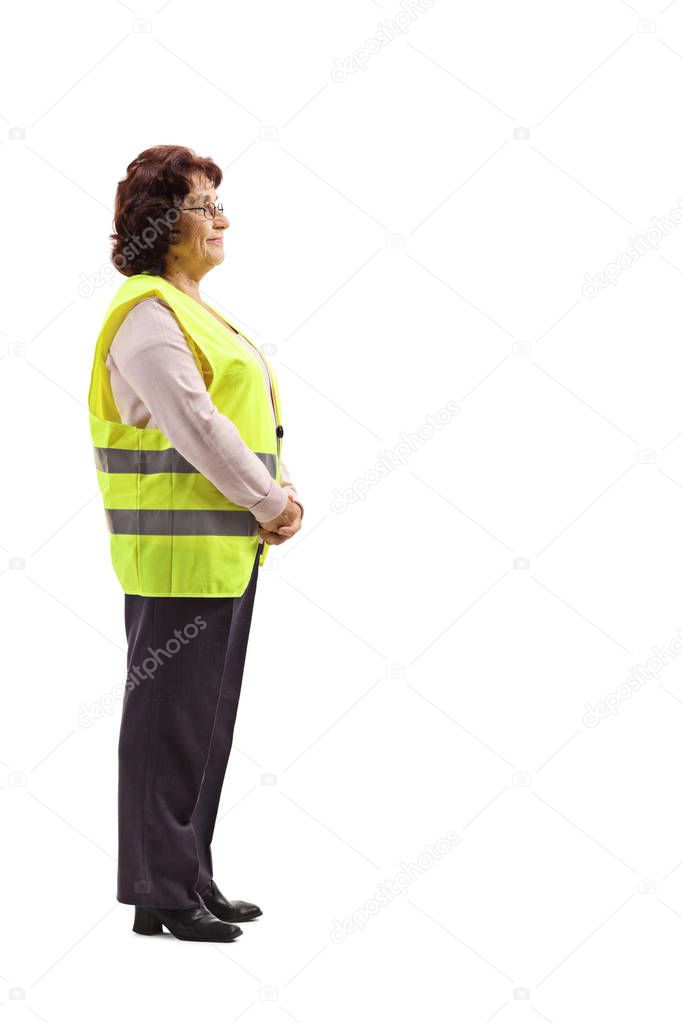 Full length shot of an elderly woman wearing safety vest, standing and waiting isolated on white background