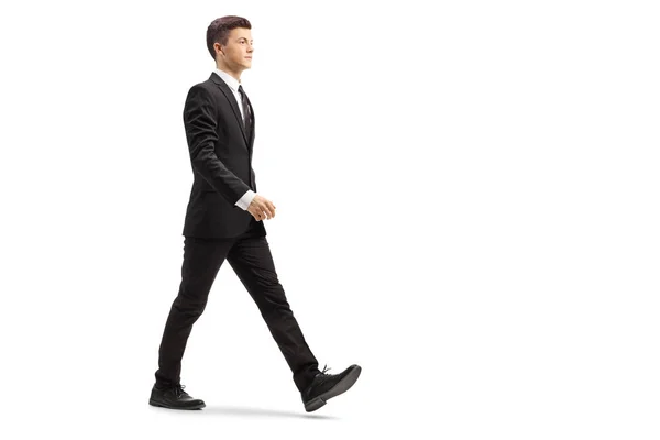 一个穿着黑色西服的年轻英俊男子在白色背景下独立行走的全景照片 — 图库照片