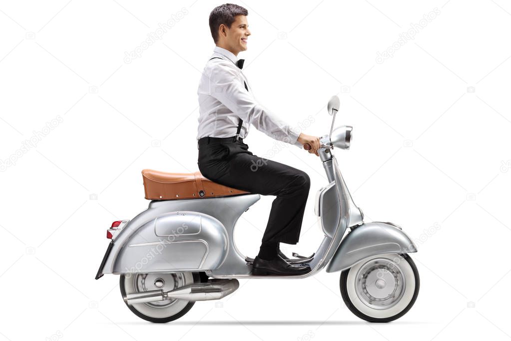 Full length shot of a young man in smart clothes riding a vintage scooter isolated on white background