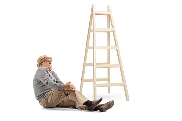 老人に座ってはしごから落ちて白い背景の上免震床と膝を保持 — ストック写真