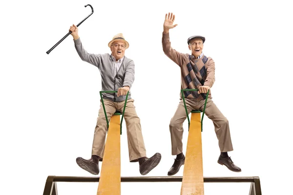 Lustige Senioren Sitzen Isoliert Auf Einer Wippe Auf Weißem Hintergrund — Stockfoto