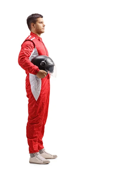 プロファイルショットを立っていると 白い背景で隔離の Halmet を保持している赤いジャンプ スーツの男性レーサーのフルの長さ — ストック写真