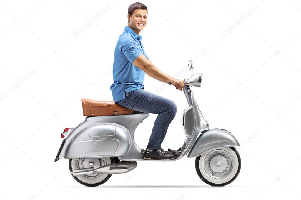 Full length shot of a happy young man riding a vintage scooter and looking at the camera isolated on white background