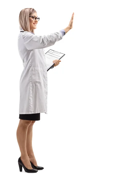 白い背景に分離されておりを身振りで示すこと若い女性医師のショットをフルの長さ — ストック写真