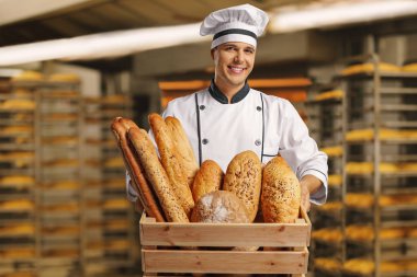 Bir sepet ekmek dolu bir fırın içinde tutarak Baker