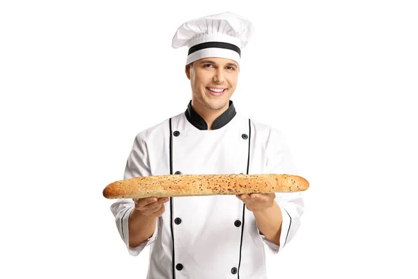 白い背景に分離されて焼きたてのバゲットのパンを持って若い男性ベイカー — ストック写真