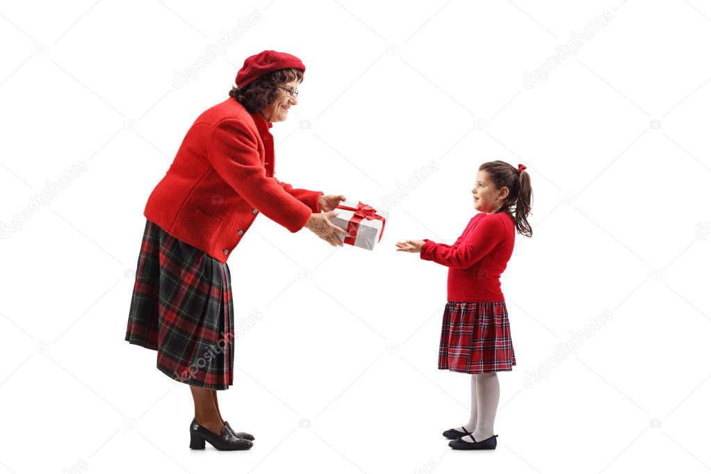 Full length shot of a senior lady giving a present to a little girl isolated on white background