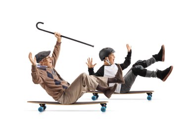 Beyaz arka plan üzerinde tam uzunlukta profil görüntüsünü bastonla bir longboard üzerinde oturan ve torunu ile sürme neşeli bir kıdemli izole