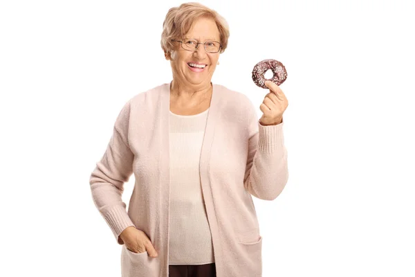 Allegro Donna Anziana Possesso Una Ciambella Cioccolato Con Spruzzi Isolati — Foto Stock