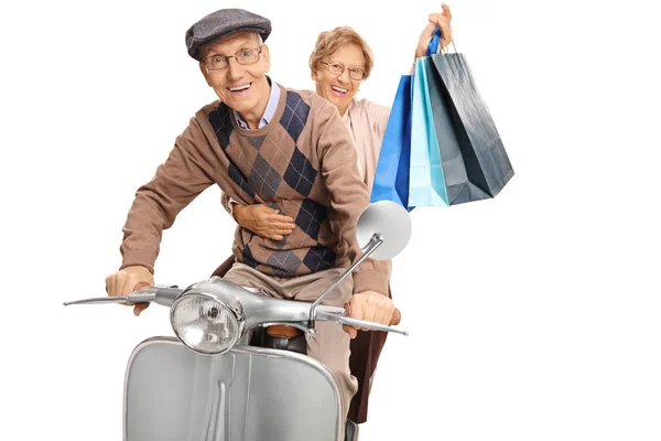 老人男人和女人与购物袋骑一个老式的滑板车孤立在白色背景 — 图库照片