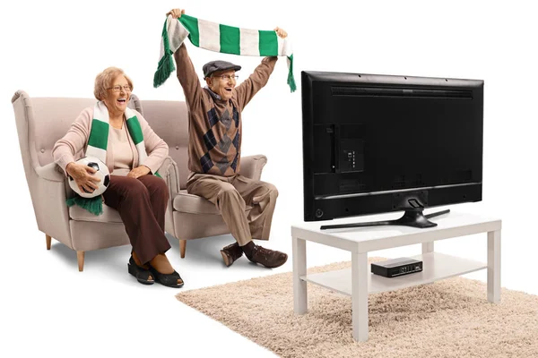 Senior female and male soccer fans cheering with a scarf and watching a game isolated on white background