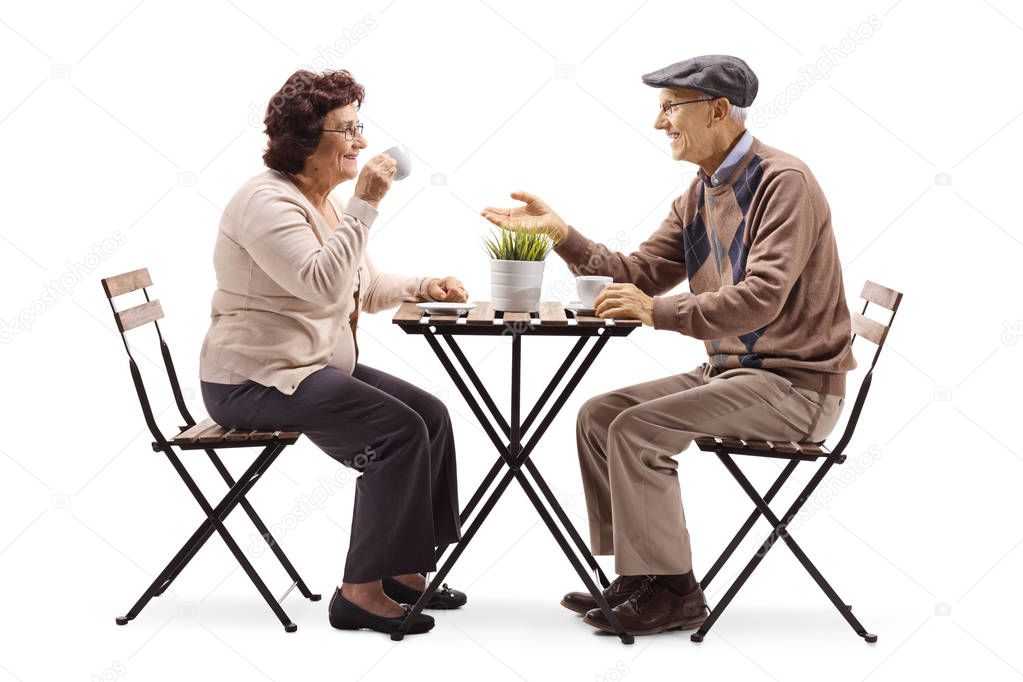 Full length shot of a senior man and woman drinking coffee and talking isolated on white background