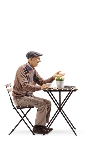 Homem Sênior Sentado Uma Mesa Café Gesticulando Uma Conversa Isolada — Fotografia de Stock