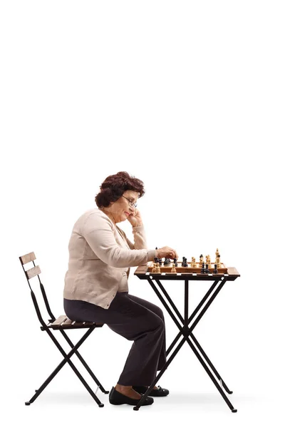 Полнометражный Снимок Пожилой Женщины Шахматной Доской Столом Смотрящей Шахматную Фигуру — стоковое фото