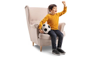 Uzunluğu atış bir koltuk futbol topu ve beyaz arka plan üzerinde izole tezahürat ile oturan küçük bir çocuk tam