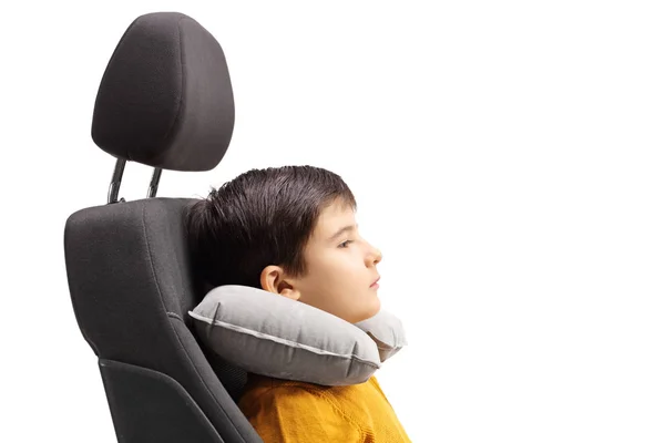 白い背景に分離された彼の首の周りの旅行枕と車の座席の少年 — ストック写真