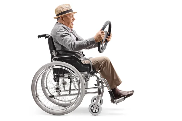 一个老人坐在轮椅上 拿着一辆在白色背景上隔离的汽车上的方向盘的全长轮廓照片 — 图库照片