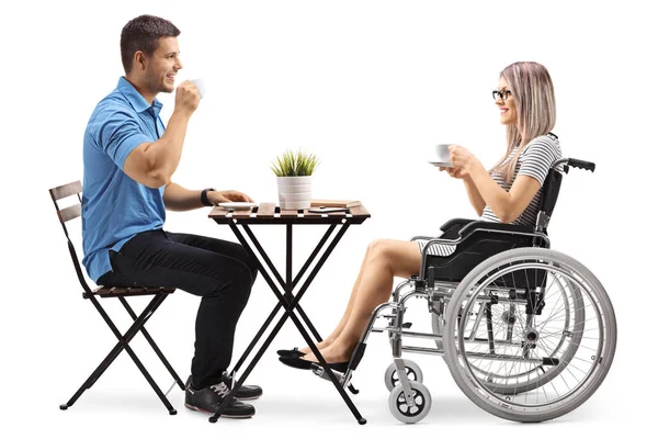 Молодой Человек Пьет Кофе Женщиной Инвалидом Инвалидном Кресле Белом Фоне — стоковое фото