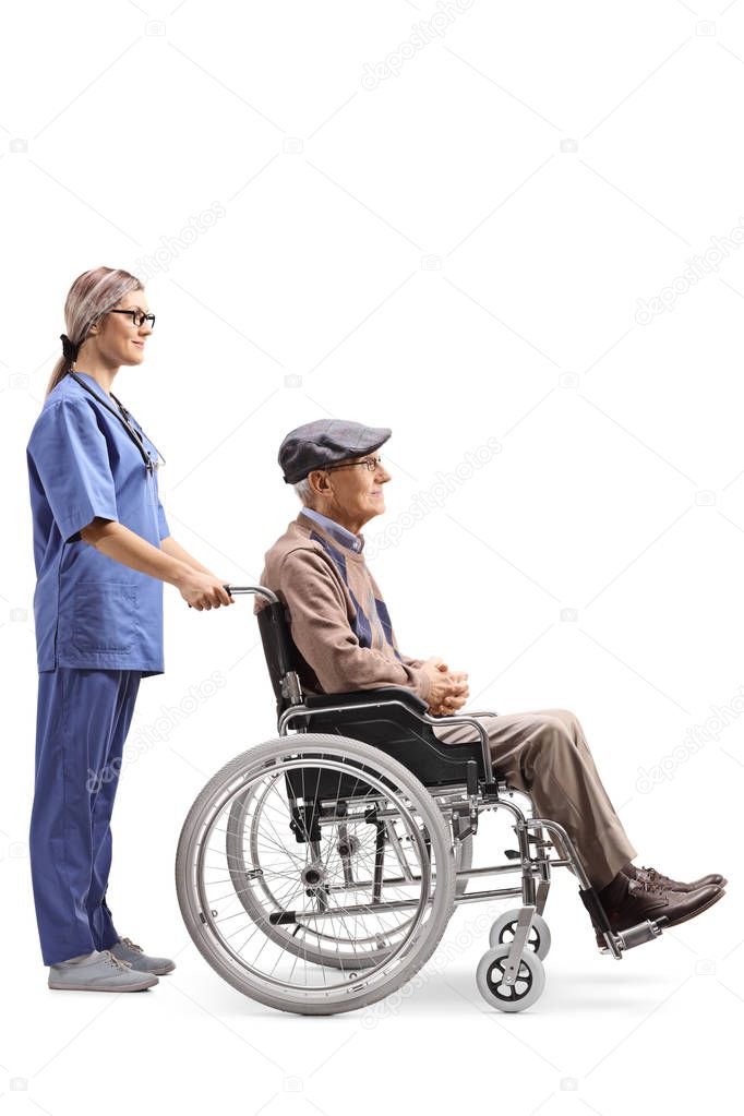 Full length profile shot of a nurse pushing a senior man in a wheelchair isolated on white background