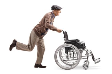 Tam uzunlukta profil atış bir yaşlı adam çalıştıran ve beyaz arka plan üzerinde izole boş bir tekerlekli sandalye itmek