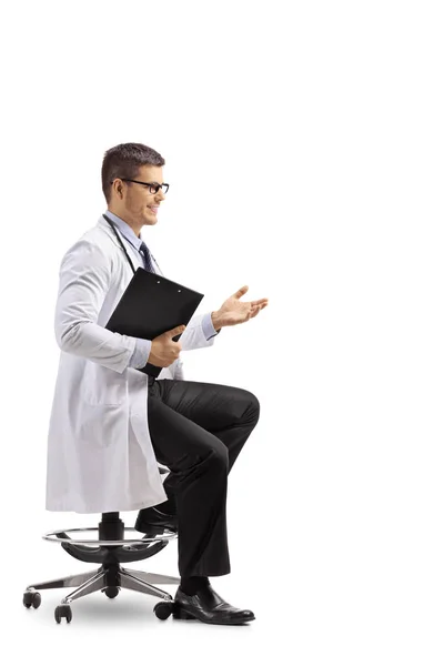 座っている若い男性医師の完全な長さを撮影し 白い背景で隔離会話を身振りで示すこと — ストック写真