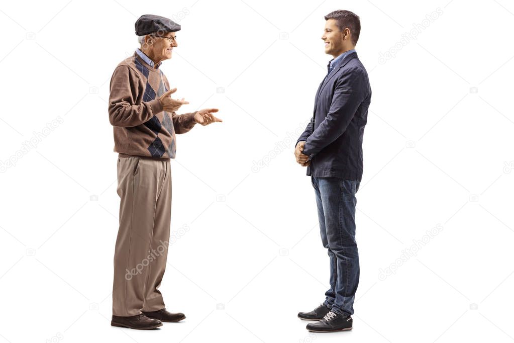Full length shot of an elderly man talking to a young man isolated on white background