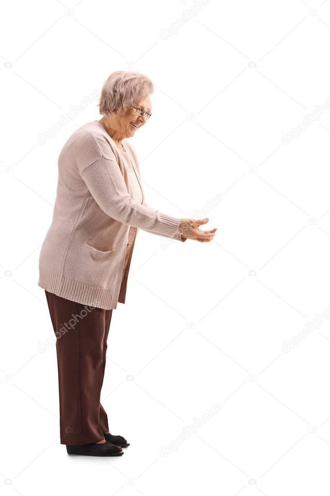 Full length profile shot of an elderly lady waiting to receive something isolated on white background