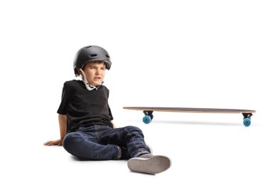 Beyaz arka plan üzerinde izole longboard ile düşme yaralandı acı içinde katta oturan kask ile küçük çocuk