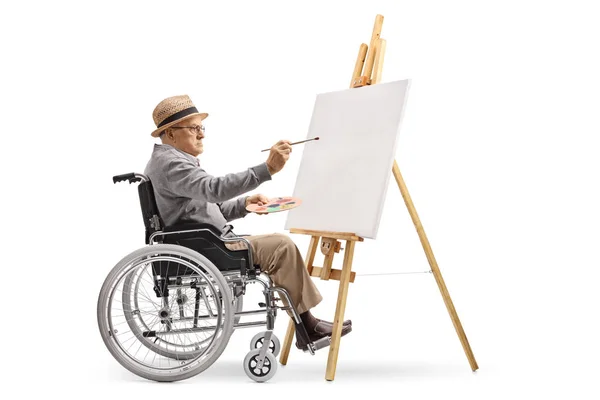 一个成熟的绅士在轮椅绘画的全长外形射击在查出的帆布在白色背景 — 图库照片