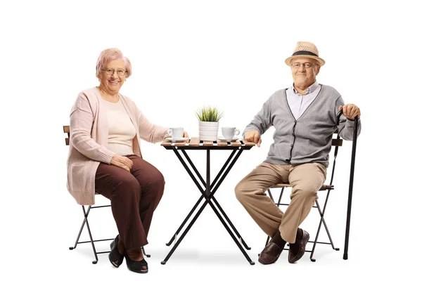老女と老人のコーヒー カップをテーブルに座って 白い背景に分離カメラで笑顔の完全な長さの肖像画 — ストック写真