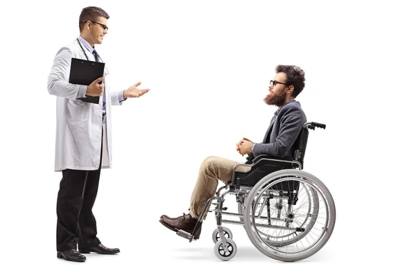 白い背景に分離された車椅子で髭の男に話す若い男性医師の完全な長さのプロフィール撮影 — ストック写真