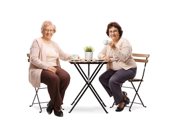 Полнометражный Портрет Двух Пожилых Женщин Сидящих Столом Пьющих Кофе Улыбающихся — стоковое фото