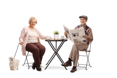 Onların köpek ile bir masada oturan ve beyaz arka plan üzerinde izole kahve keyfi kıdemli Çift