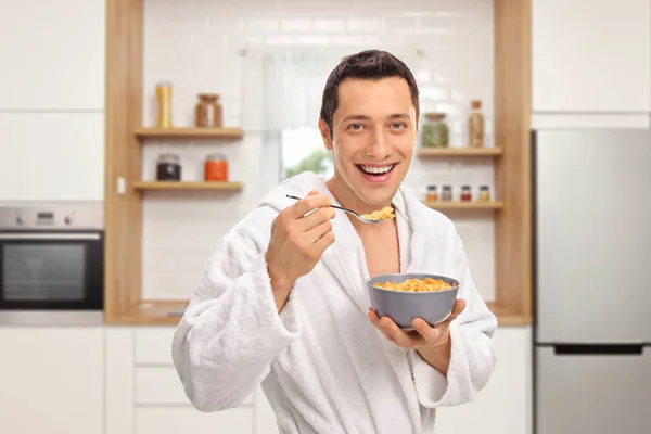 Joven Sonriente Una Bata Comiendo Cereal Tazón Una Cocina — Foto de Stock