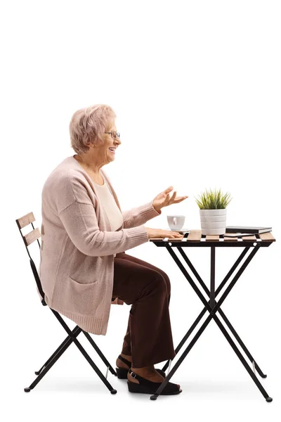 Полнометражный Снимок Пожилой Женщины Сидящей Столом Кофе Жестикулирующей Рукой Белом — стоковое фото