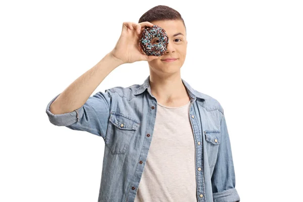 白い背景に分離されたドーナツを覗く若い男 — ストック写真