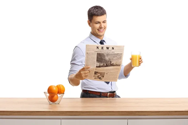 Ung Man Skjorta Läsa Tidning Och Håller Ett Glas Apelsinjuice — Stockfoto