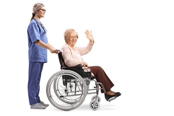 Full Length Profile Shot Nurse Pushing Senior Woman Wheelchair Waving — Stock Photo, Image