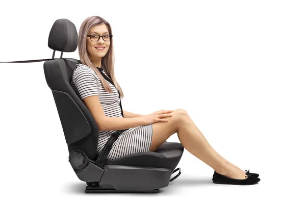 一个年轻的女乘客在汽车座椅上的全长镜头 系好安全带 对在白色背景上孤立的相机微笑 — 图库照片