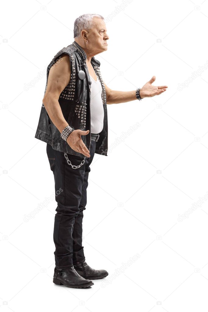 Full length profile shot of a mature man in a leather vest with an angry expression gesturing with hand isolated on white background