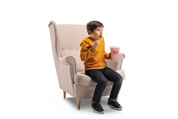 ポップコーンは 白い背景で隔離の肘掛け椅子に興奮した男の子 — ストック写真