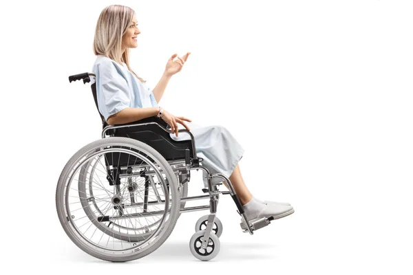 白い背景に分離されて彼女の手でジェスチャー車椅子の若いメスの患者の完全な長さのプロフィール撮影 — ストック写真