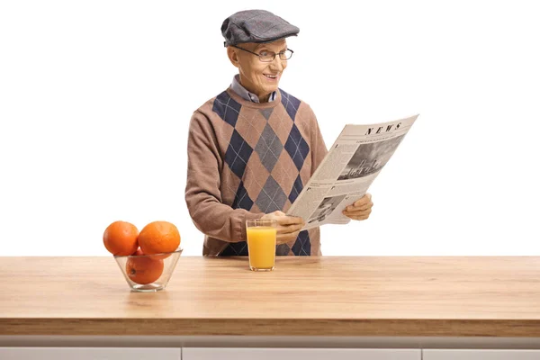 Starszy Człowiek Czytając Gazety Stojąc Ladą Drewniane Pomarańczy Sok Pomarańczowy — Zdjęcie stockowe