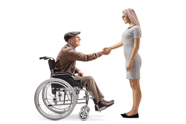 白い背景に分離された若い女性と握手車椅子で幸せな年配の男性の全身ショット — ストック写真