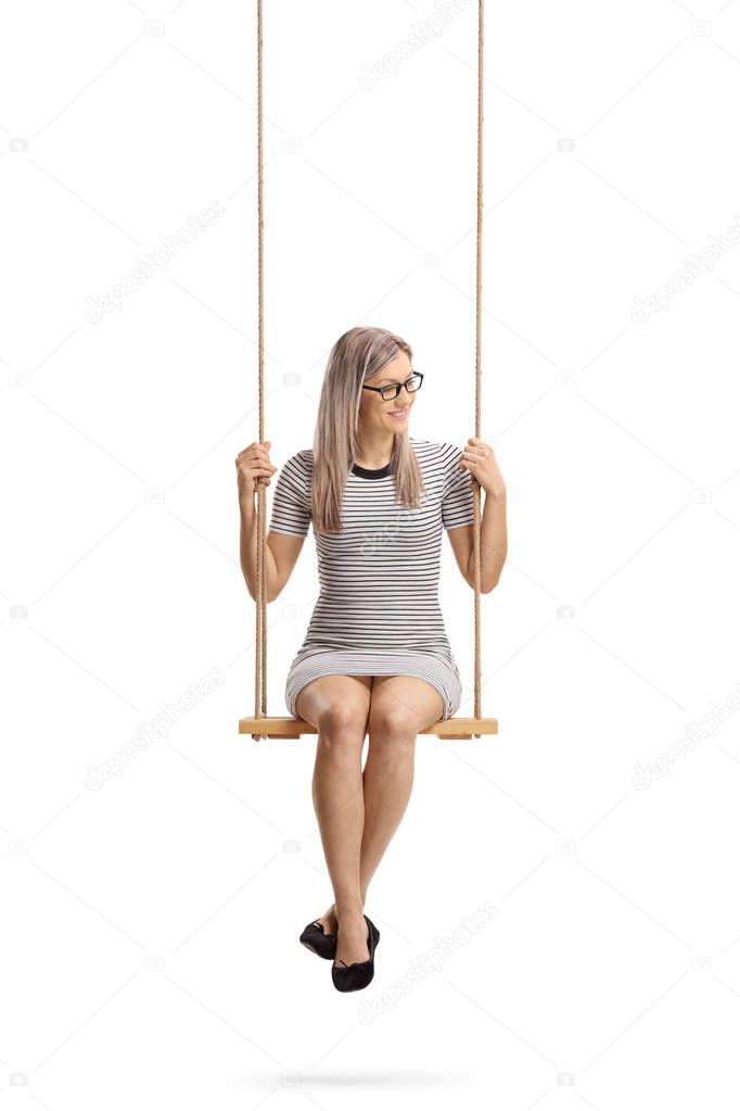 Full length shot of a young cheerful woman sitting on a swing  isolated on white background
