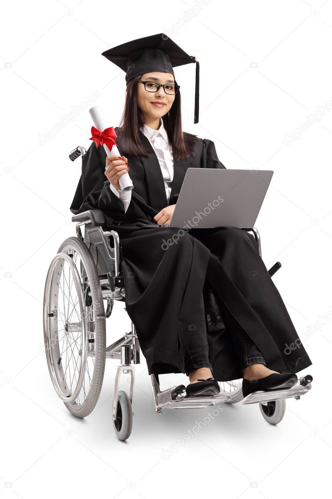 Full length shot of a young woman in a wheelchair wearing a graduation gown and holding a diploma and laptop isolated on white background