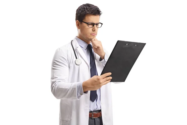 Young Male Doctor Looking Paper Clipboard Thinking Isolated White Background — Stock Photo, Image