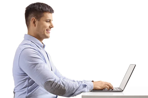 一个年轻人在白色背景上被隔离的笔记本电脑上打字的个人资料 — 图库照片
