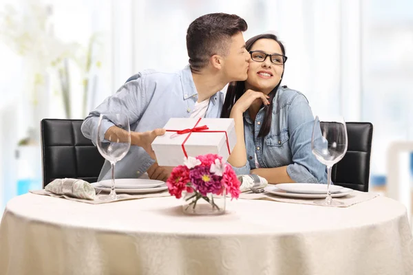 Joven Chico Besando Una Chica Dando Regalo Una Mesa Restaurante —  Fotos de Stock