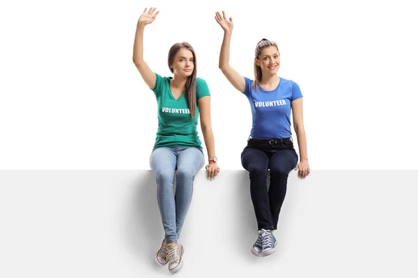 Full Length Portrait Young Women Volunteers Sitting White Panel Waving — Stock Photo, Image